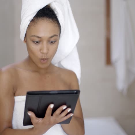 Young-Woman-Wearing-Bath-Towel-Using-Tablet-Computer