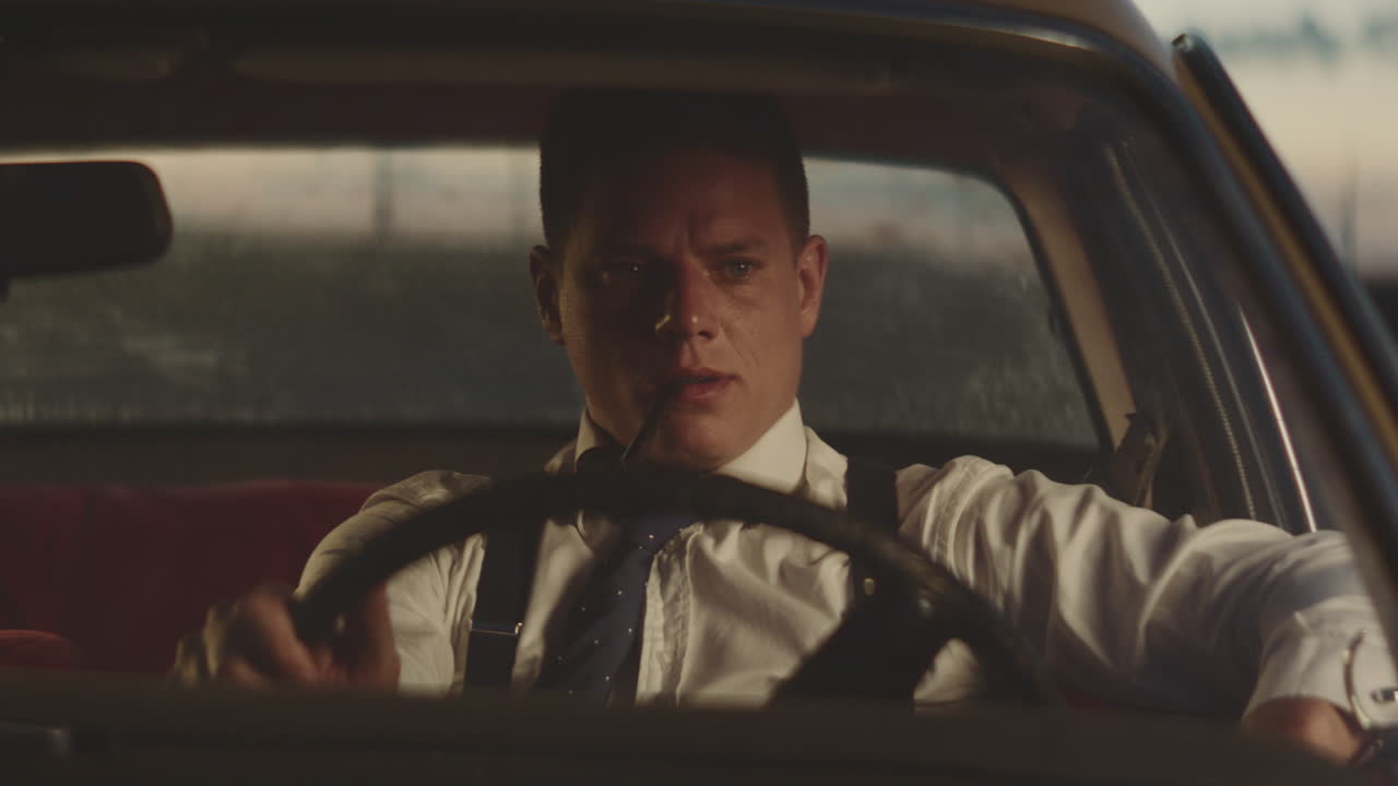 밤에 빈티지 자동차를 운전하는 남자