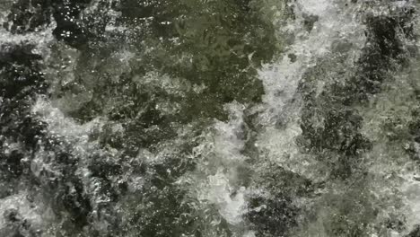 vista de cerca del agua del río verde arremolinada creada por el poder de un motor fuera de borda