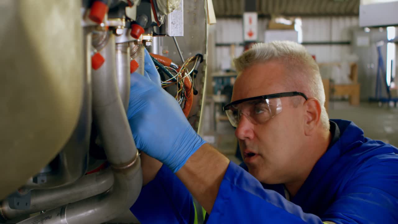 Engineer repairing aircraft engine in hangar 4k
