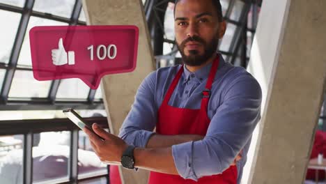 Like-icon-with-increasing-numbers-over-speech-bubble-over-african-american-man-using-digital-tablet