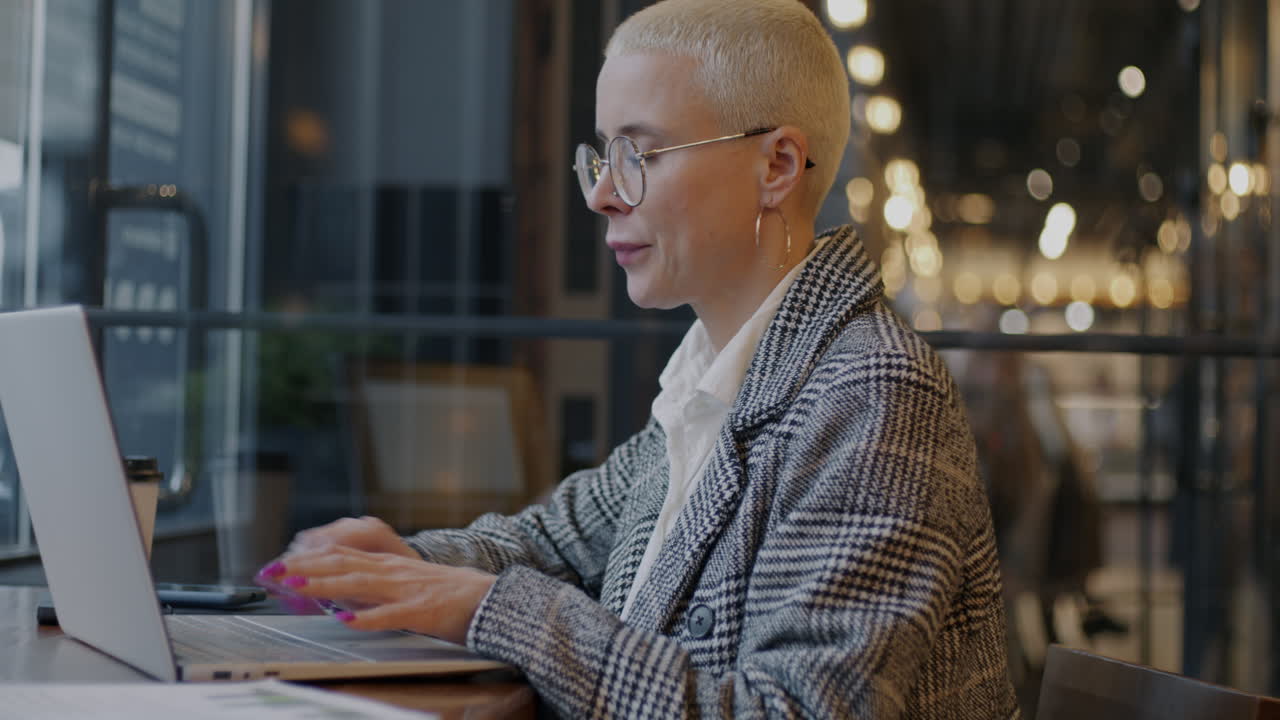 Woman Working on Laptop in a Cafe