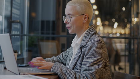 mujer trabajando en una computadora portátil en un café