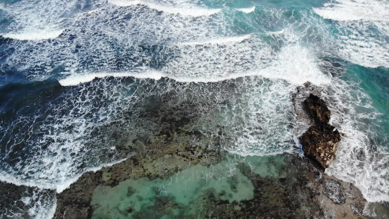 Aerial drone view of waves hitting the rocks on the shore in Limassol, Cyprus