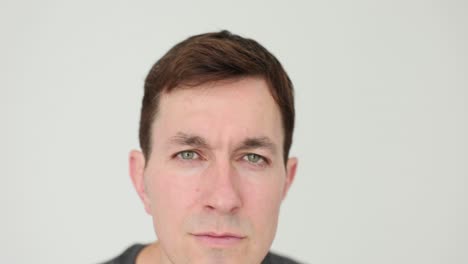 a man's serious portrait against a plain background