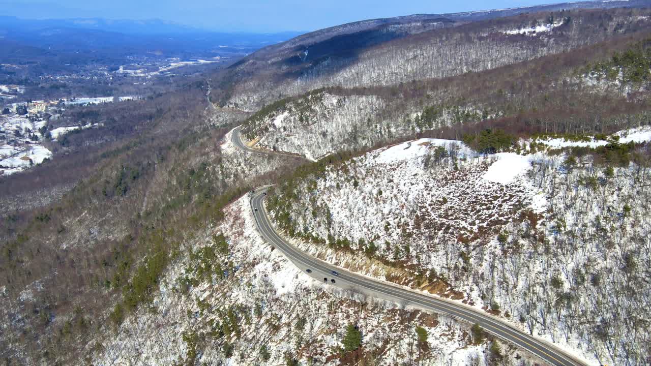 imágenes de video de drones aéreos de una carretera nevada del valle de la montaña del cielo azul a través de las montañas en los apalaches en la cresta de shawangunk, en el estado de nueva york
