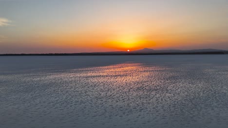 Flying backward over dry Larnaca salt lake during golden hour, Cyprus