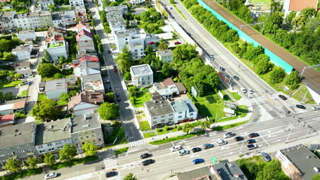 aerial view of a suburban area in gdynia orłowo, poland, featuring residential houses, a busy intersection with cars, and adjacent green spaces