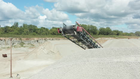 drone circling conveyor belt at limestone quarry - aerial focus view