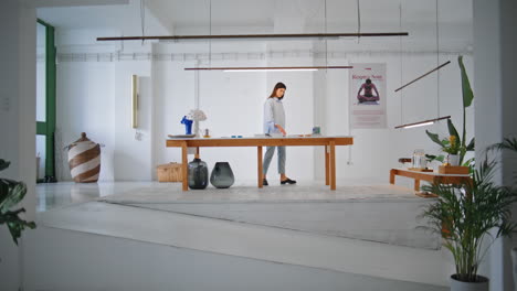 woman going art center on weekend. calm brunette checking artworks on table