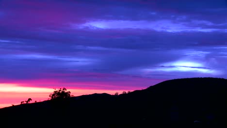 time lapse of a silhouetted hillside from just after sunset to early evening