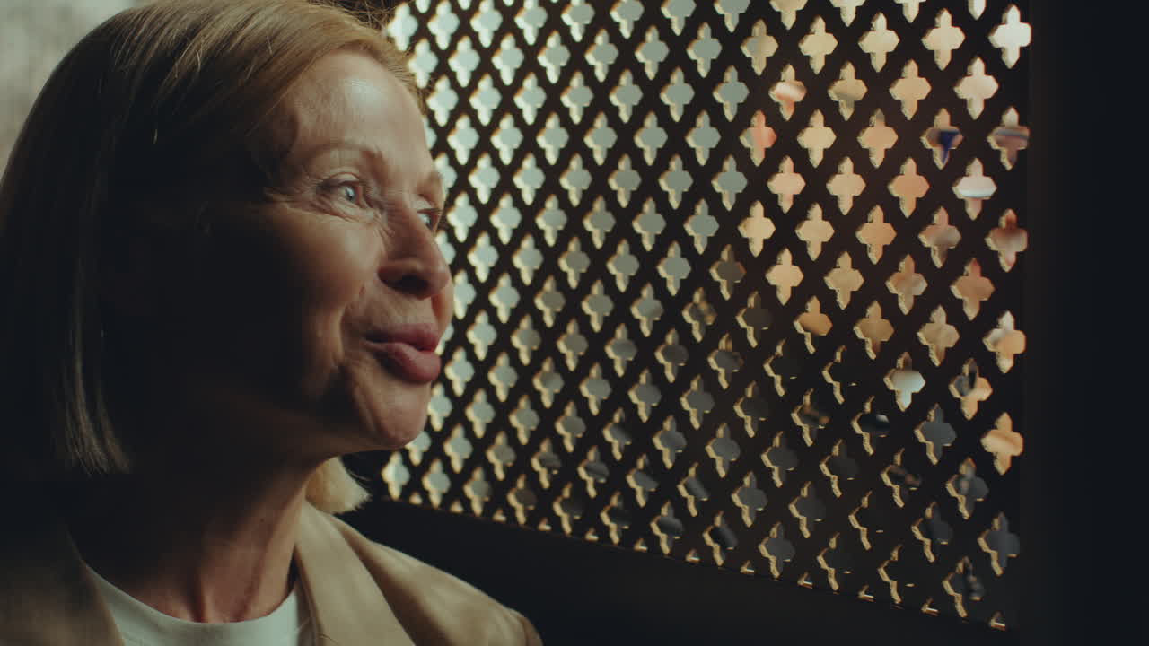 Senior Woman Having Conversation with Priest Sitting in Confessional