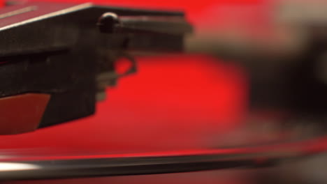 slider move on a red retro record players needle and a vintage vinyl music album