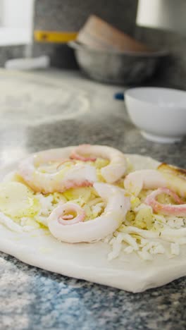 chef putting some oil during the pizza with octopus preparation