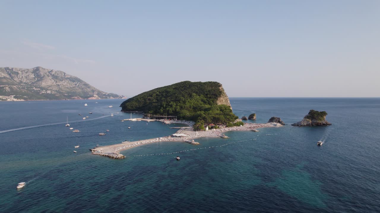 Sveti Nikola Island, Budva, Montenegro from above ocean as boats drive over reef