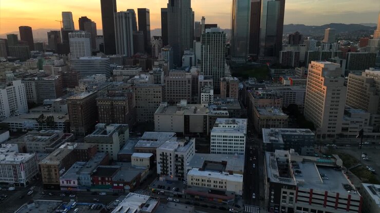 Rivelatrice ripresa con drone di Downtown Los Angeles CA USA al tramonto, torri finanziarie centrali e quartiere