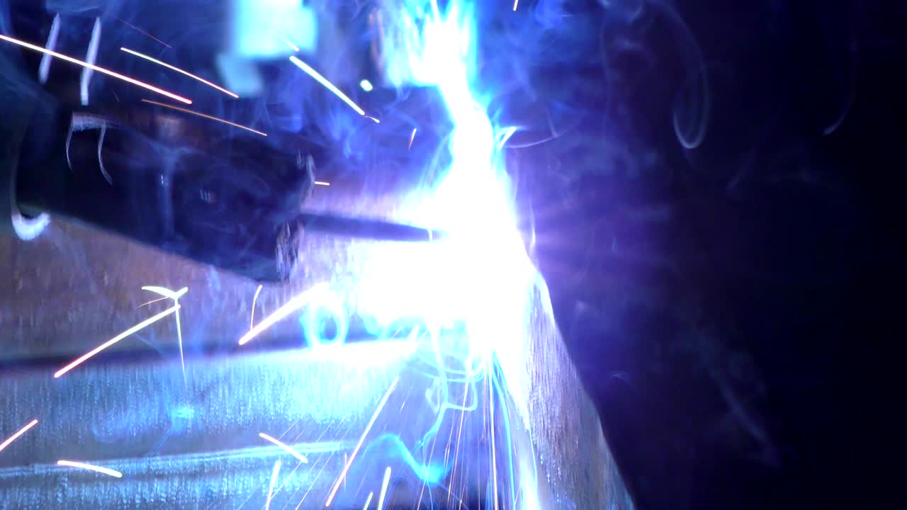 The sparklers and the flash of light when welding the joints of iron