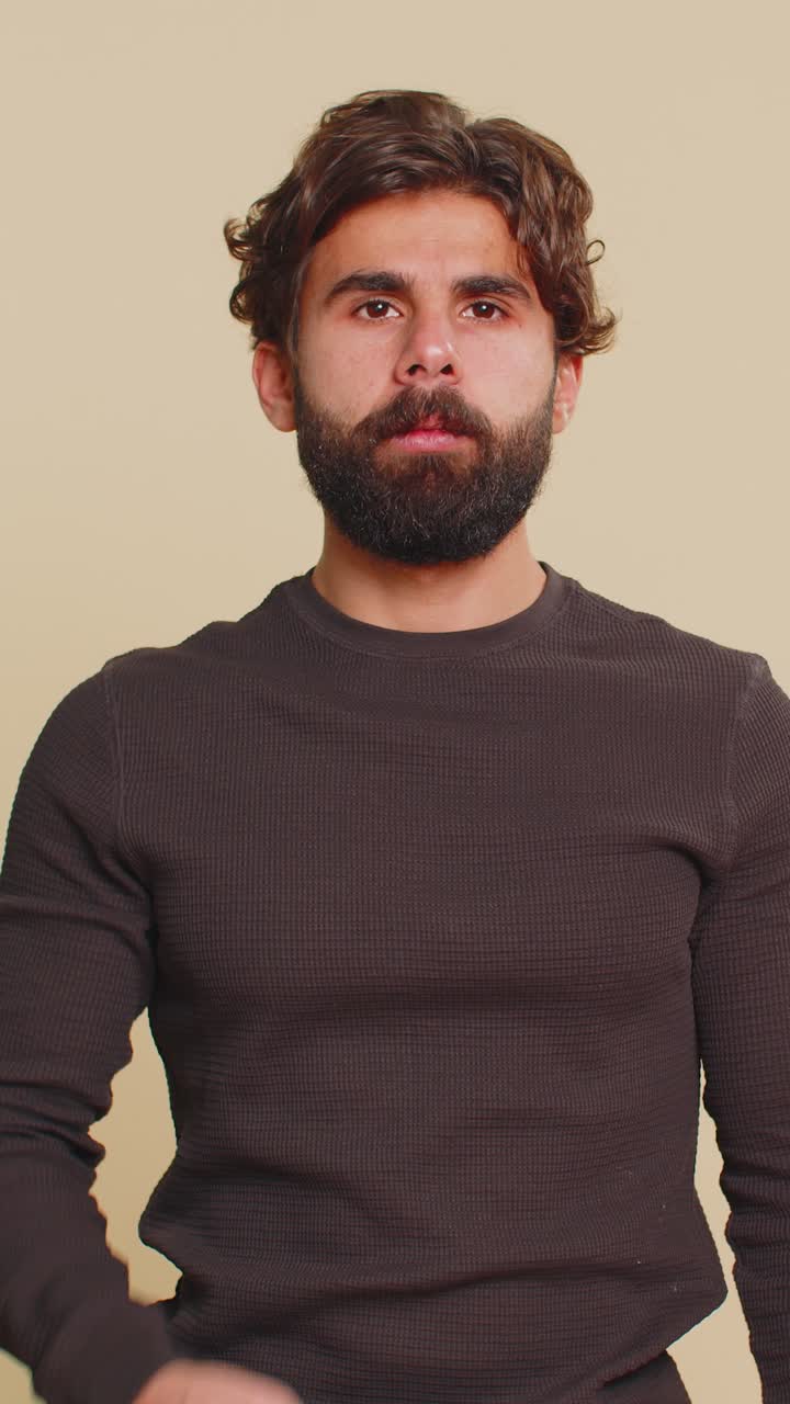 Unhealthy lebanese young man coughing covering mouth with hand feeling sick over beige background