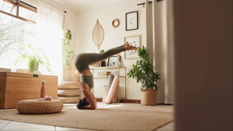 woman practicing headstand yoga at home