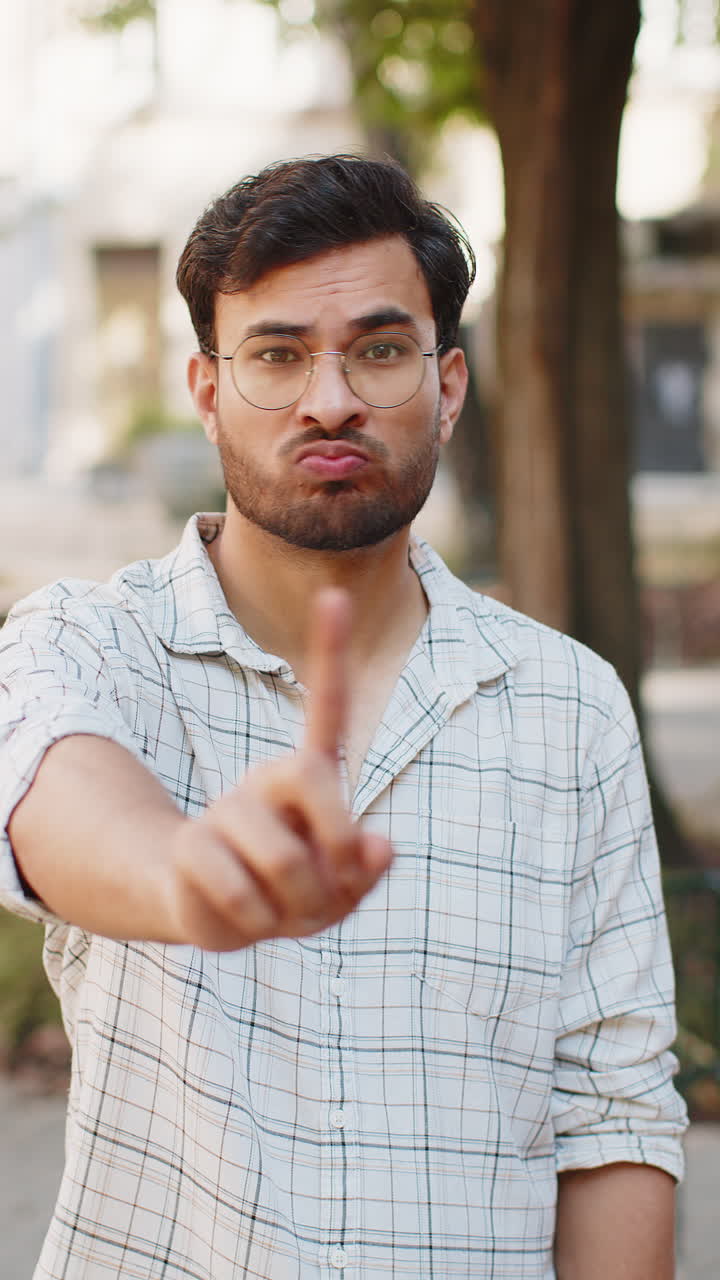 Upset indian man reacting to unpleasant idea dissatisfied with bad quality wave finger on street