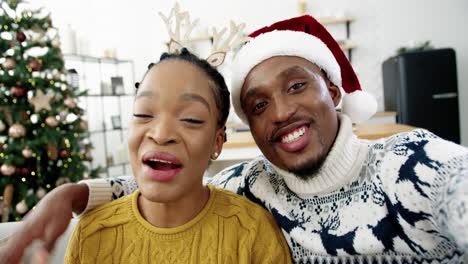 Pov-De-Una-Pareja-Feliz-De-Hombre-Y-Mujer-En-Casa-Con-Un-árbol-De-Navidad-Decorado-Chateando-En-Video-En-Línea-Y-Diciendo-Saludos-Navideños-A-Amigos-Y-Familiares