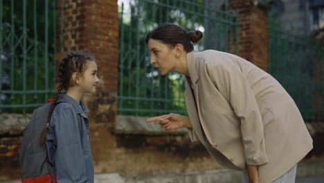 mother and daughter arguing outside school