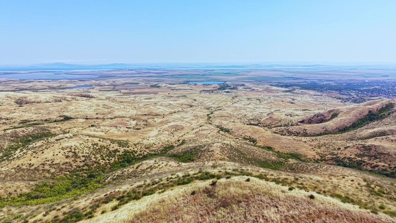 Ampia vista di paesaggio rurale con colline e campi sotto un cielo sereno di giorno