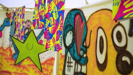 cut out symbols of a star and heart made by children in kids are hanged on a string inside a tent that has been painted on