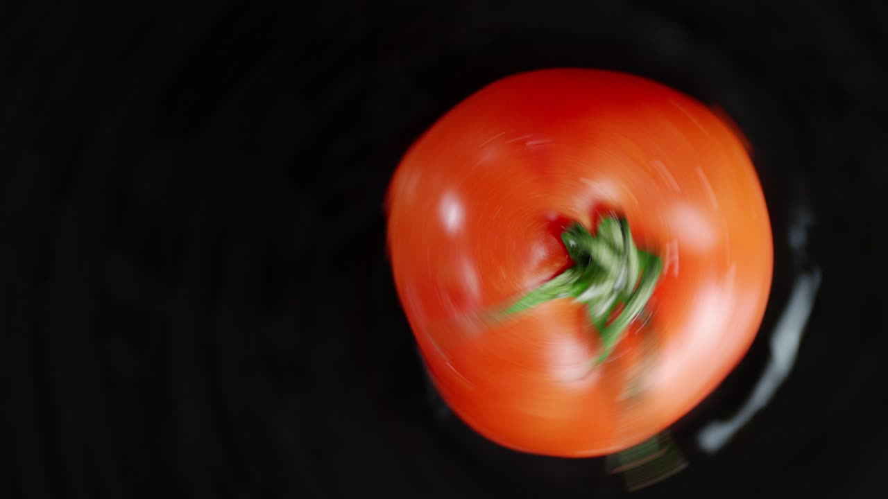 테이블 위에 회전하는 신선한 토마토 하나.