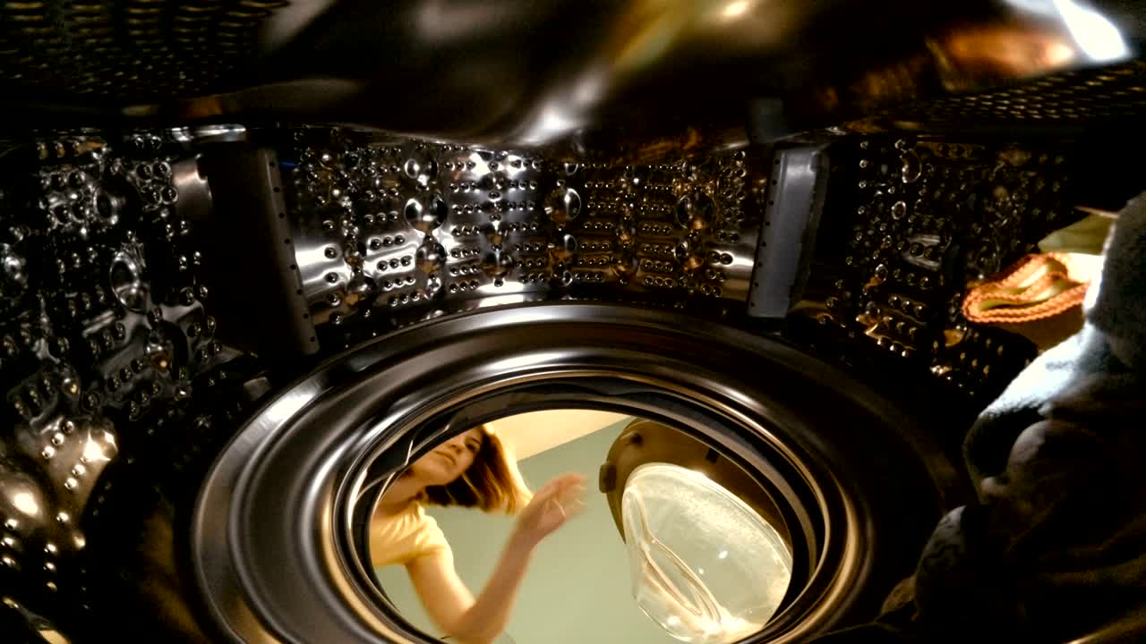 세탁기. 소녀는 세탁기에 물건을 던집니다.