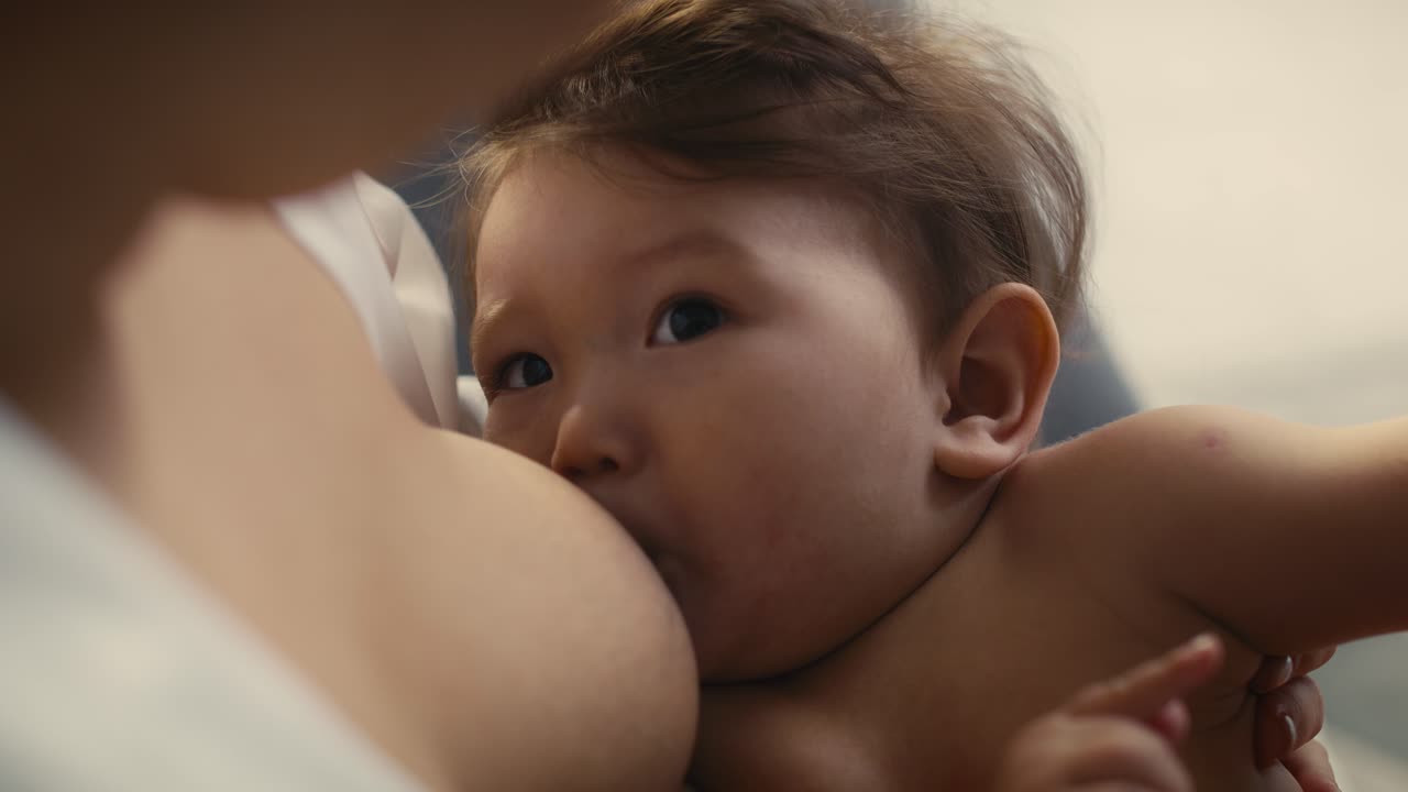 Cute Asian baby breastfed by mother
