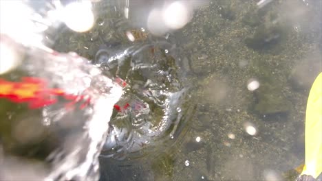 top view of dropping a magnet for magnet fishing in slow motion into a river and watching the splash and bubbles as the fisher searches for treasures on the river bead