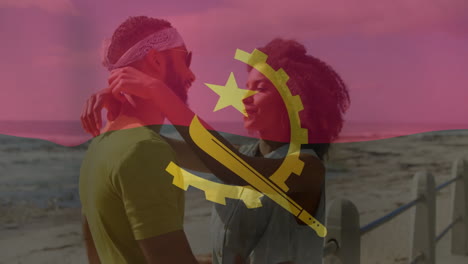 embracing couple on beach with angola flag animation in background