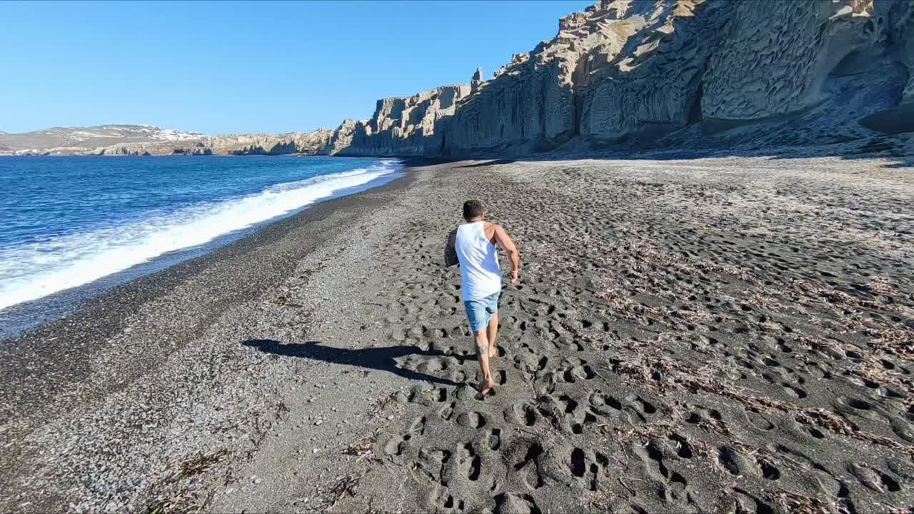 man running on vlychada beach