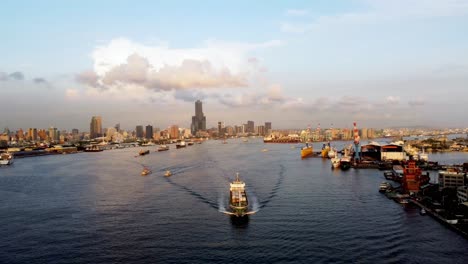 Ein-Geschäftiger-Hafen-Mit-Schiffen-Und-Kränen-Während-Der-Goldenen-Stunde,-Luftaufnahme