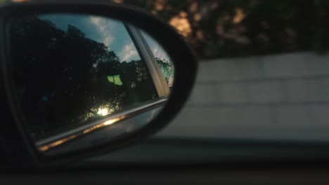 reflection of trees and sky on the rear view mirror