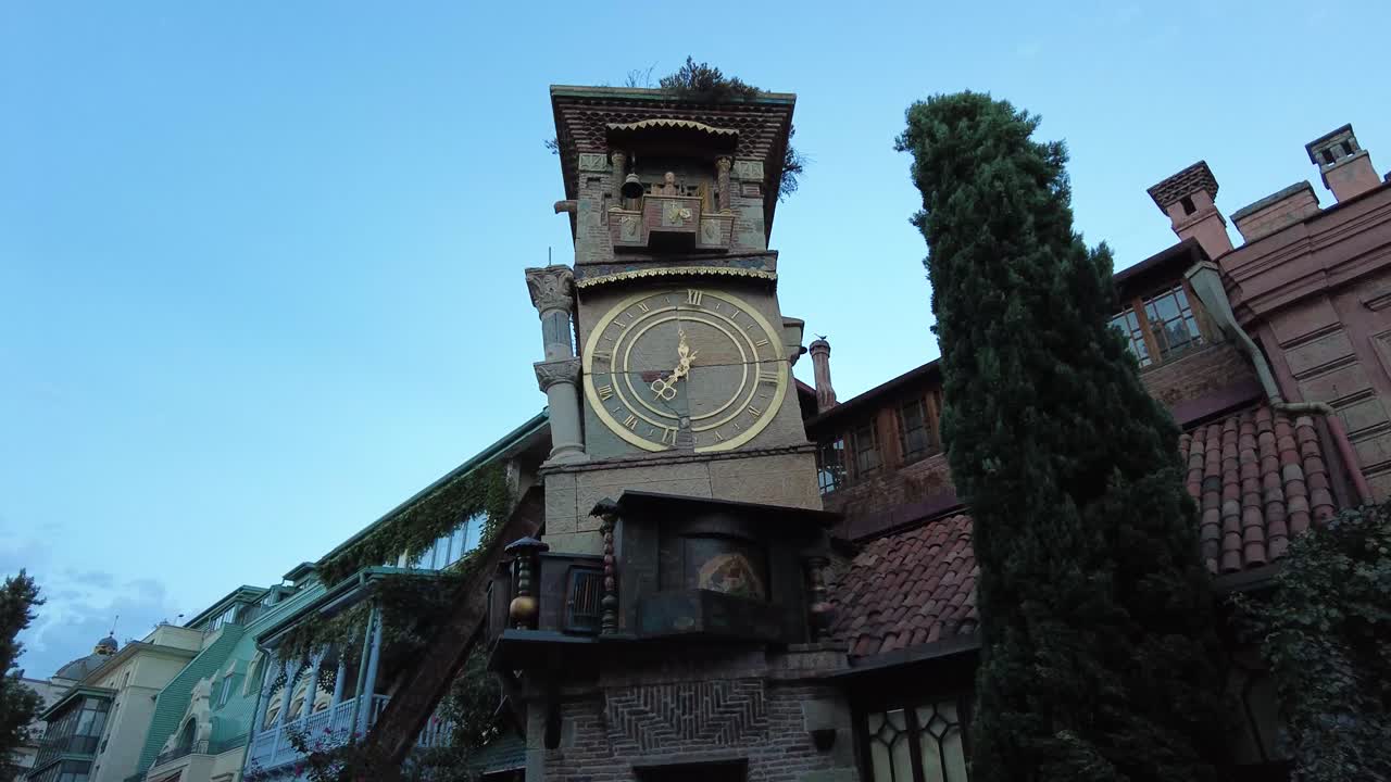 Golden hands of clock tower in Tbilisi the asymmetric building made by old city ruins by modern art architect in down town old city of Tiflis walking tour tourist attraction landmark scenic shot