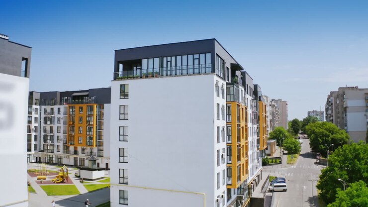 Urban background in sunny daytime. Exterior of a new apartment building. Modern design of high-rise building with large windows and balconies.