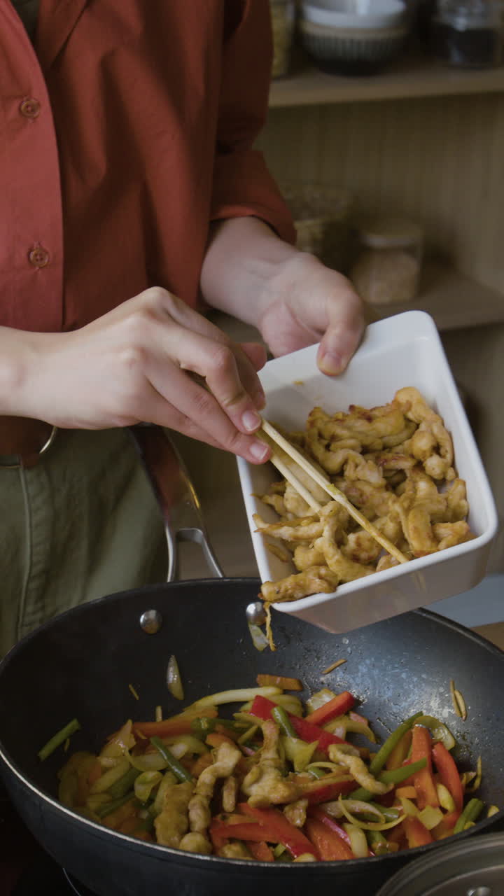 Woman Cooking Stir-fry with Chicken and Vegetables in a Wok