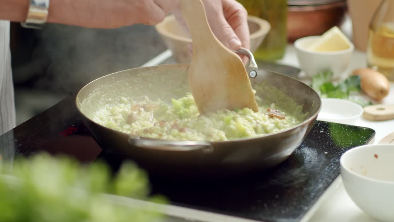 작물 요리사 가 팬 에 뜨거운 리소토 를  ⁇ 고 있다
