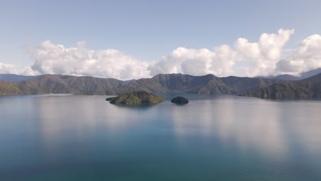 小小島<br > 位於海邊壯觀的山脈前面, 厚厚的雲彩反射在藍色海水中