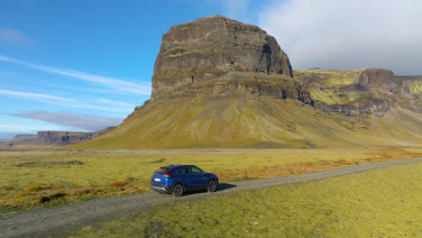 conduciendo un coche con la vista de la colosal montaña rocosa de lomagnupur en el sur de islandia