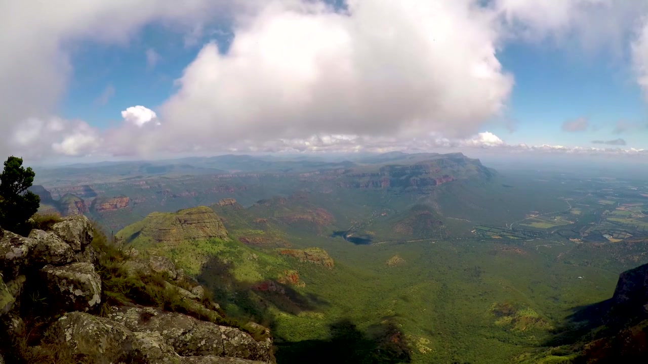 A smooth time lapse of clouds billow up and flow around this African valley surrounded by mountains.