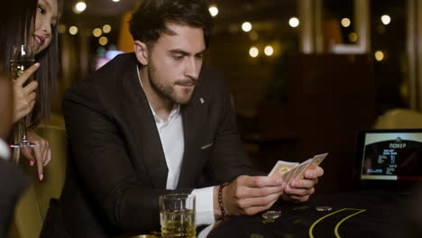 man looking at his hand of cards.