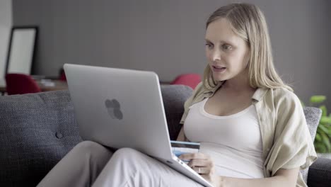 cheerful pregnant woman shopping online with laptop