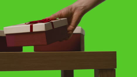 Close-Up-Of-Man-Picking-Up-Gift-Wrapped-Present-From-Table-Shot-Against-Green-Screen-2