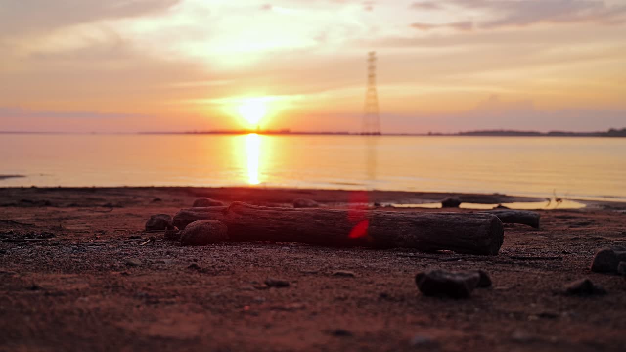 Solnedgang over Daugava-flodens bred med silhuet af kraftoverføringstårn
