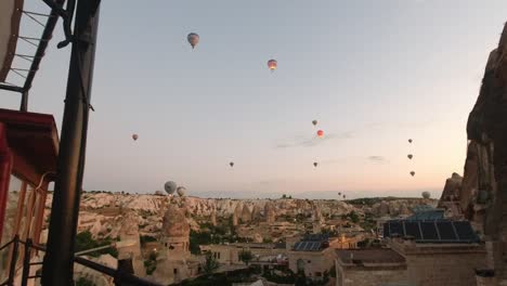 view of the hot-air balloons floating in the air from one of the famous cave hotels located in the historical ancient rock structures in cappadocia, turkey