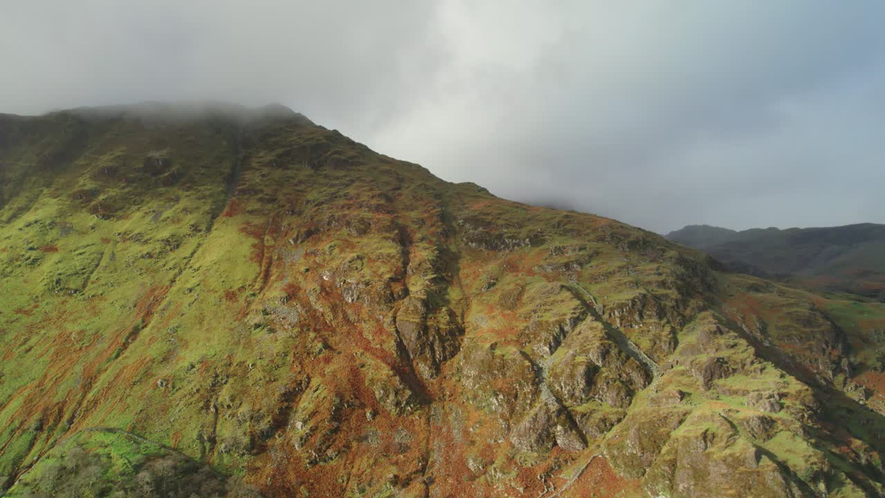montaña cerca del lago llyn gwynant envuelto en nubes e iluminado por la luz del sol, gales en el reino unido