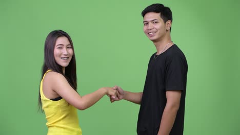 young asian couple shaking hands together
